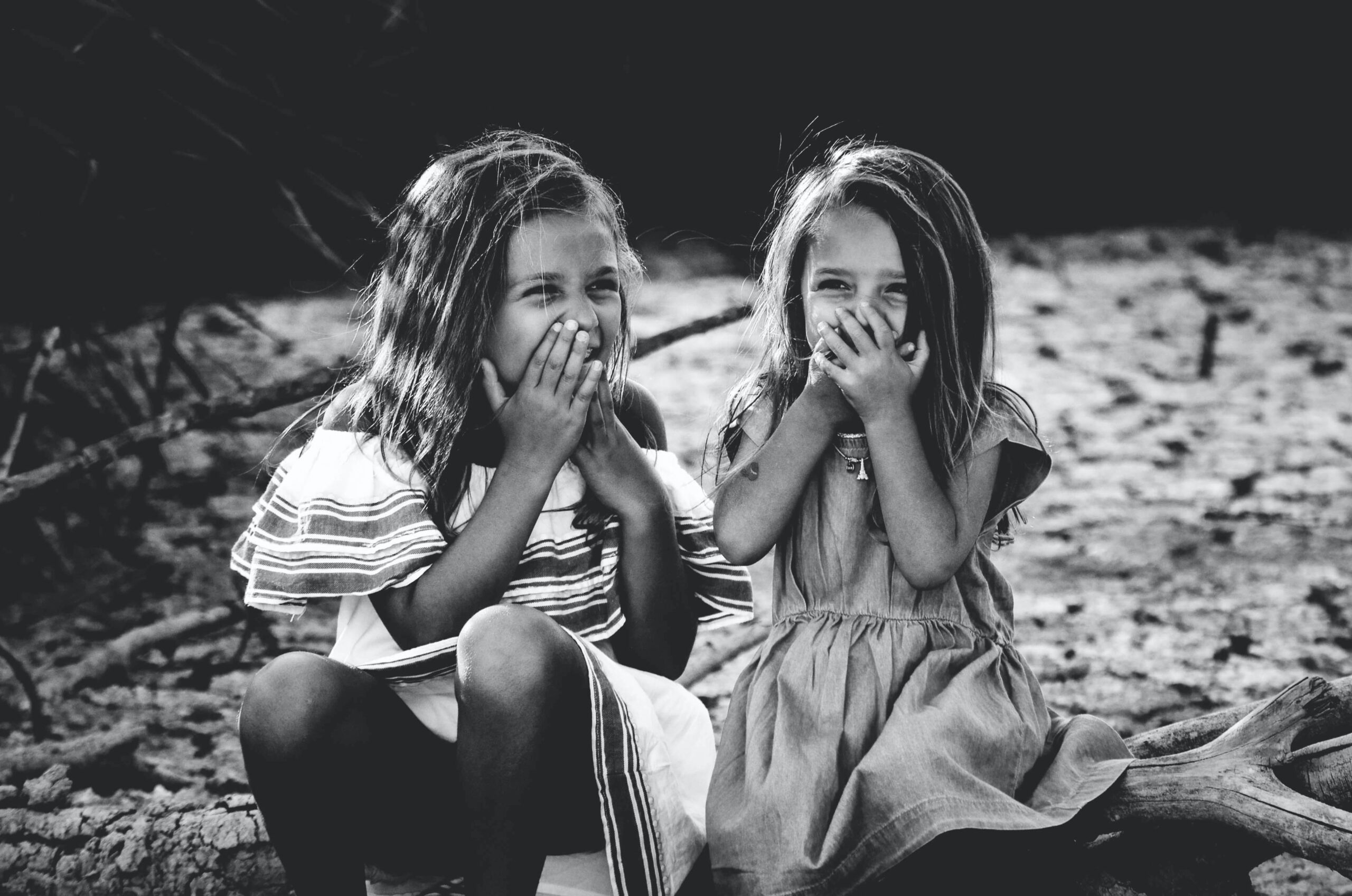 Zwei Mädchen sitzen beieinander und lachen